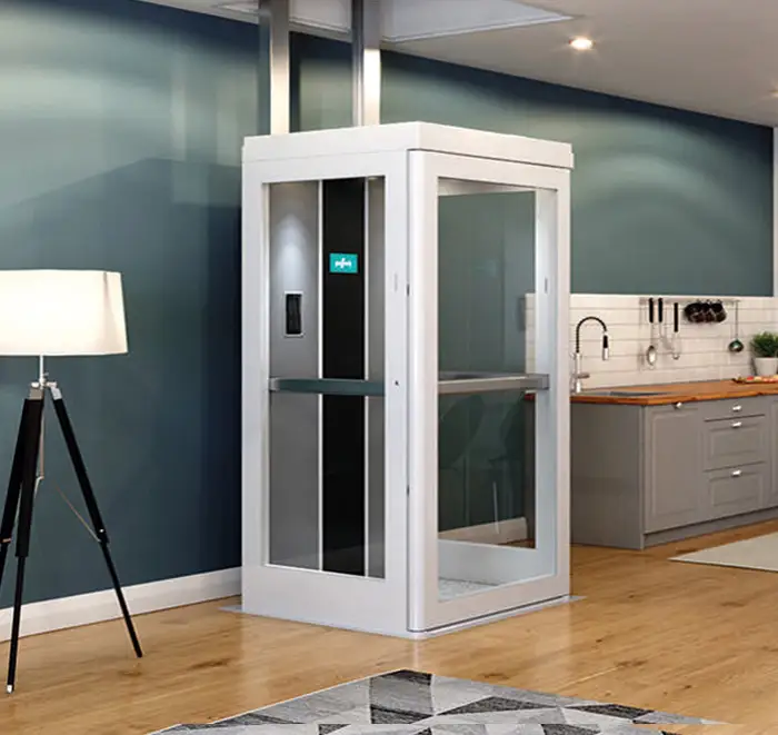 The through the floor home accessibility lift is downstairs with the door closed. The rails are at the rear of the lift, and the lift is made of full-height clear panels.